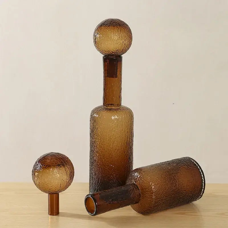 A textured amber glass decanter with frosted spherical stoppers in the decorbites clear glass vase set for living room decor