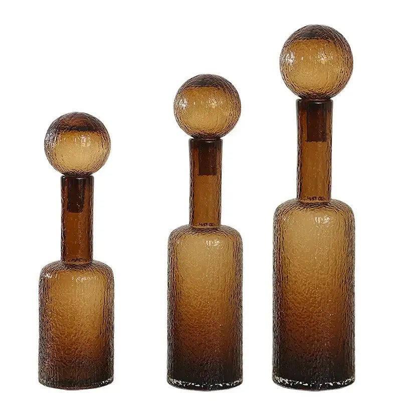 Set of three amber textured decorbites clear glass decanters with spherical stoppers for living room decor