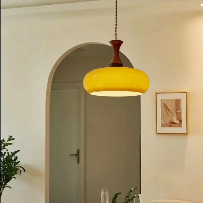 Vibrant yellow amber led pendant light with rounded glass bowl and dark wood metal fixture for kitchen decorbites pendant light