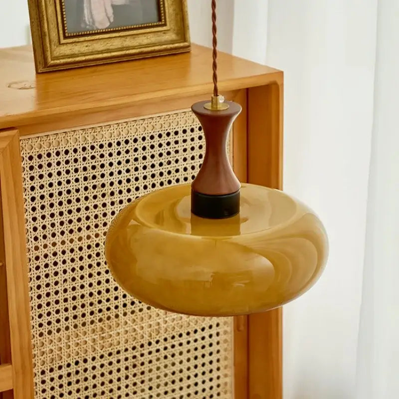 Warm amber led pendant light with rounded glass bowl and dark wood-tone metal fixture for kitchen decorbites amber led
