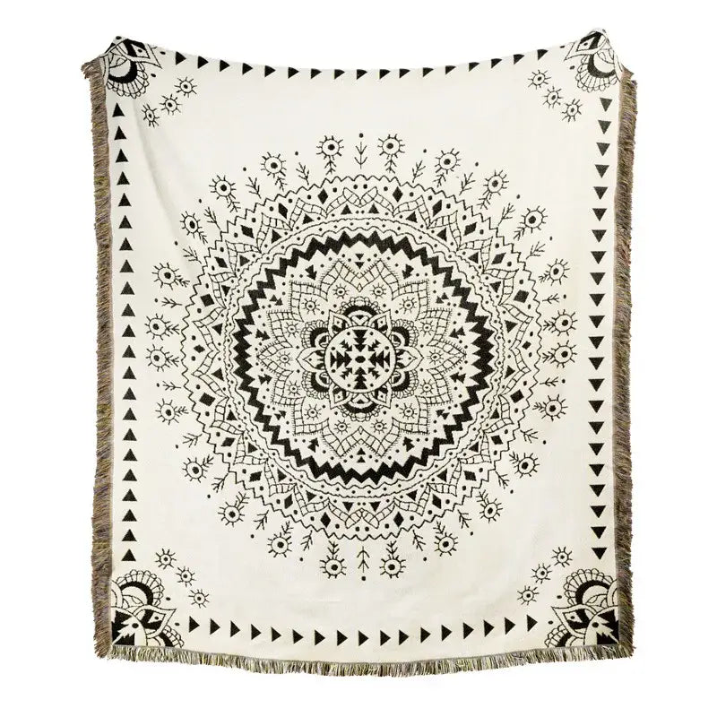A cream-colored throw blanket with a detailed black mandala design and fringe edges, ideal as a beach blanket sofa cover