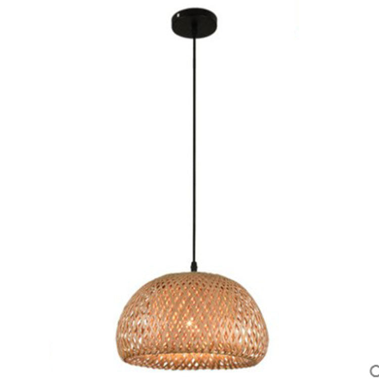 Rattan dome pendant light with black metal hardware and a warm glow.