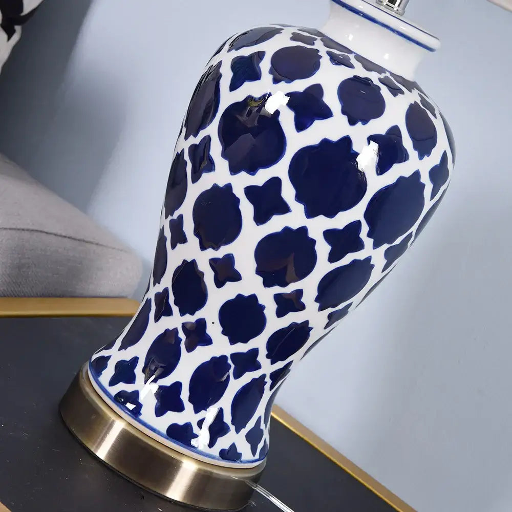 Glossy white ceramic table lamp with blue floral pattern and gold-toned circular foot by decorbites blue ceramic