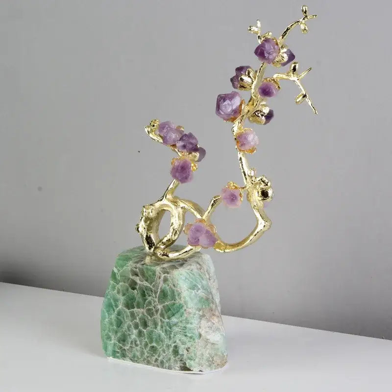 Gold-toned brass tree ornament with faceted purple amethyst stones on a textured green moss agate base