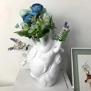 Decorbites™ anatomical heart resin vase in white filled with blue, green, and purple artificial flowers for glam decor