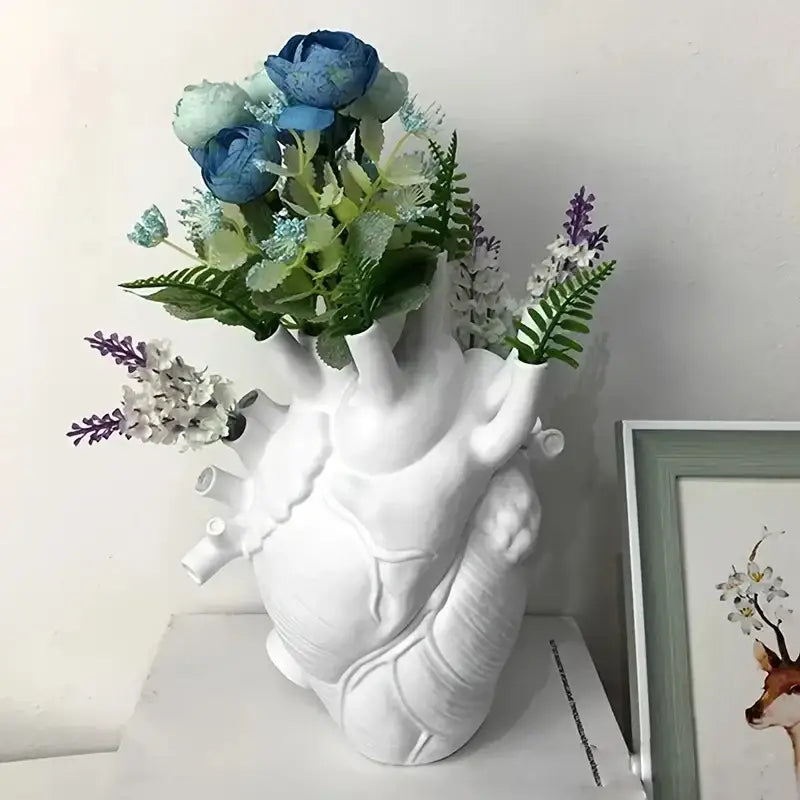 Decorbites™ anatomical heart resin vase in white filled with blue, green, and purple artificial flowers for glam decor