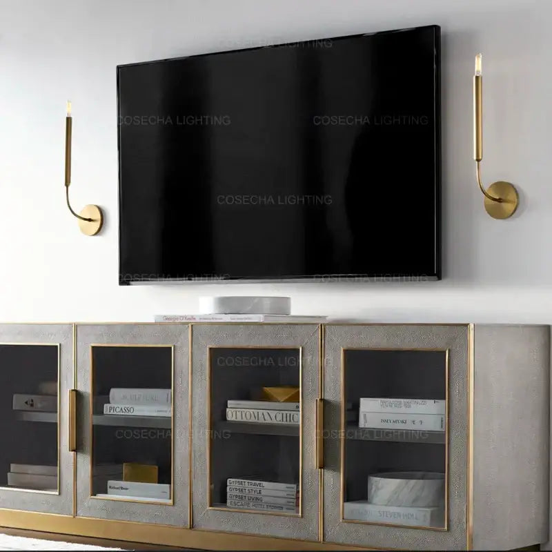 Antique art deco gold-toned candle-style wall lamps with sleek curved arms serve as elegant mirror lights for living rooms