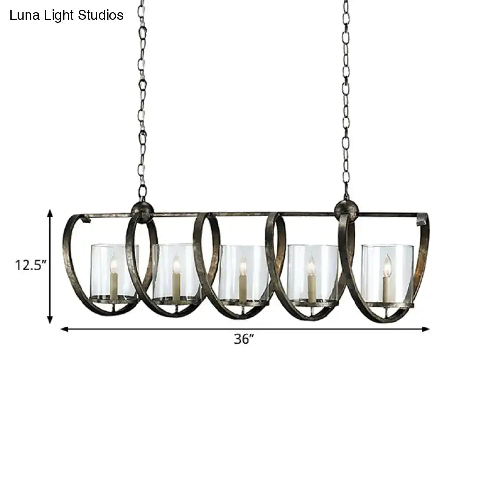 Antique brass dining room chandelier with five clear glass candle holders and lit white taper candles