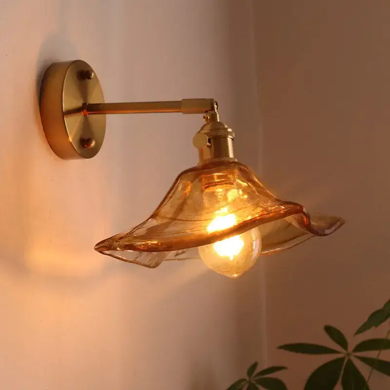 Antique brass and amber glass copper led wall light with scalloped shade and brass-finished arm for bedroom use