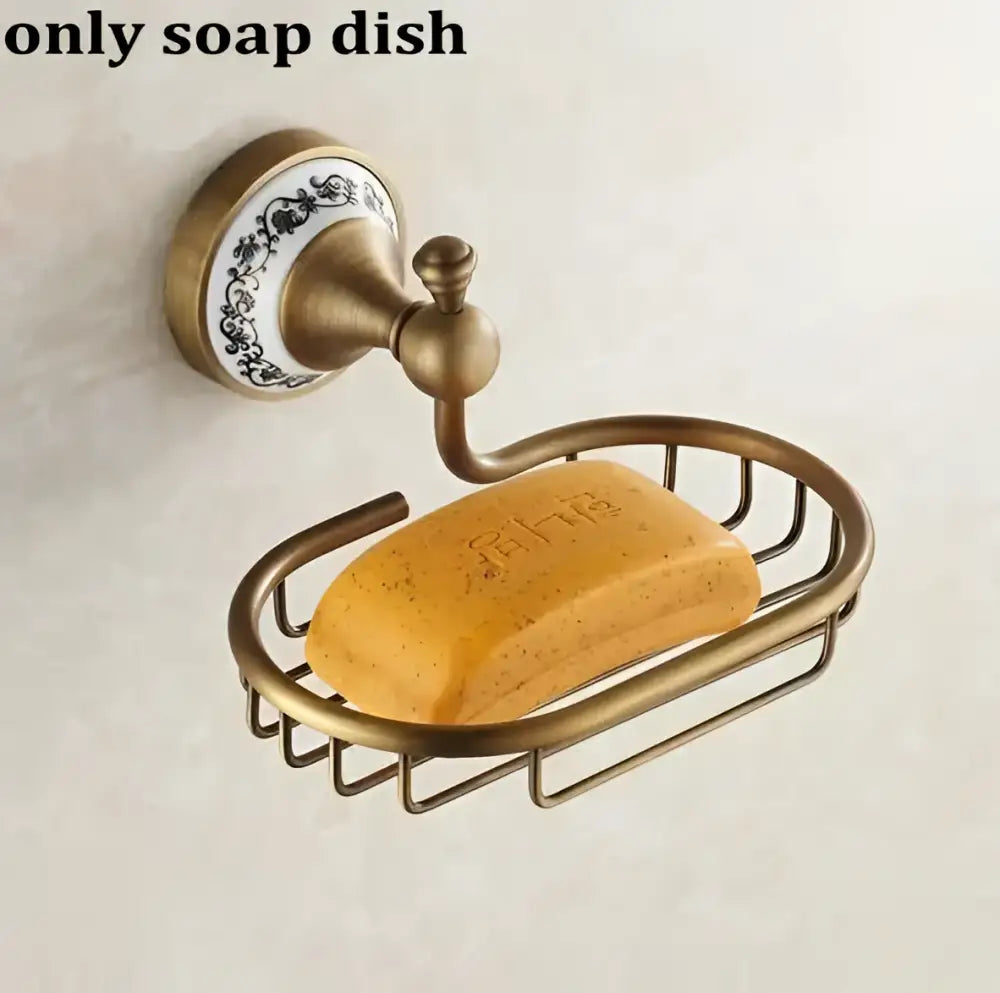 Antique brass and ceramic wall-mounted soap dish with ornate backplate and wire basket holding yellow soap in decorbites bathroom accessories set