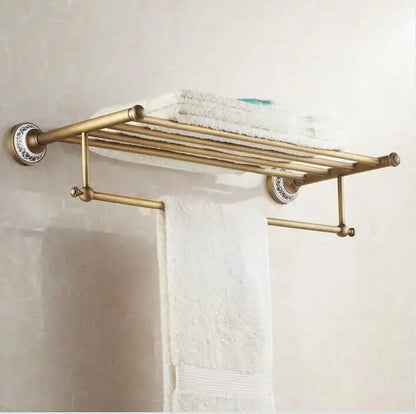 Antique brass and ceramic tiered towel rack with ornate circular mounts holding white towels in decorbites bathroom accessories set