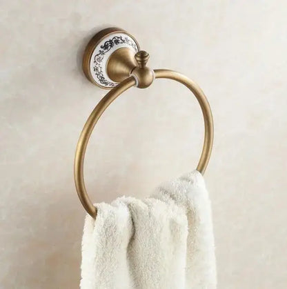 Antique brass towel ring with decorative white ceramic plate and black floral patterns from decorbites bathroom accessories set
