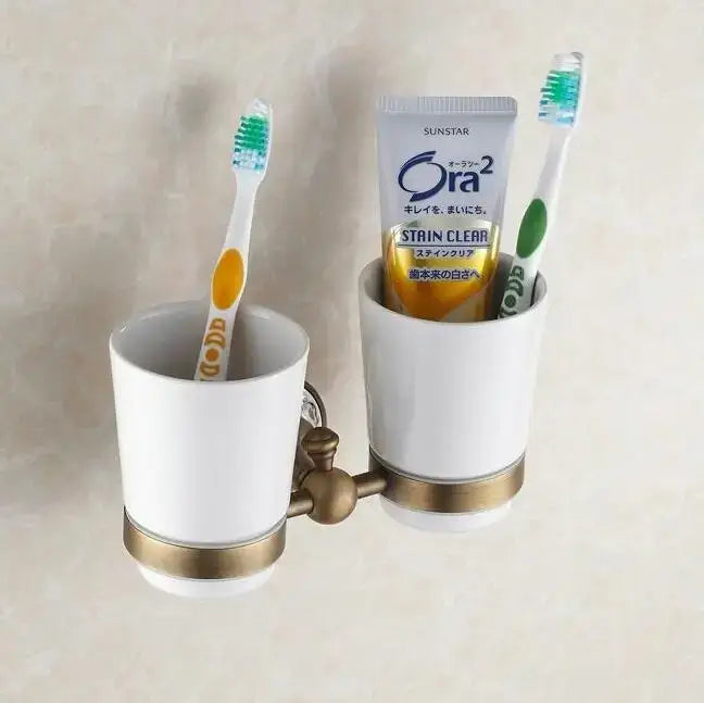 White ceramic toothbrush holder with gold-toned metal accents and bracket from decorbites bathroom accessories set