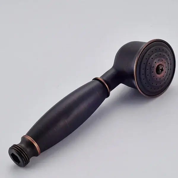 Antique brass and chrome hand shower head with bronze finish, ergonomic handle, and circular spray face with multiple nozzles