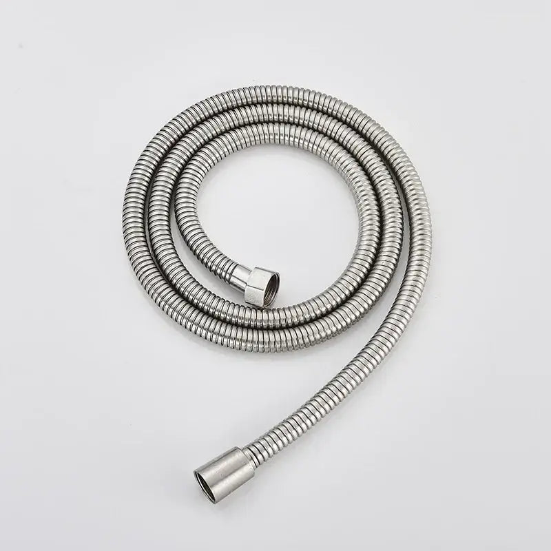 A coiled metallic silver flexible shower hose with ribbed texture for antique brass and chrome hand shower head bathroom sprayer