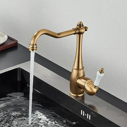 Antique brass basin waterfall faucet with white ceramic handle and elegant curved spout for kitchen use