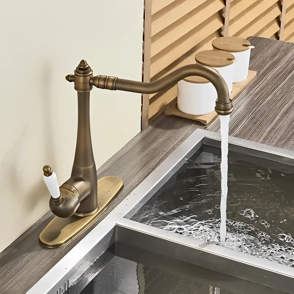 Antique brass basin waterfall faucet with curved spout and white ceramic handle for kitchen basin use