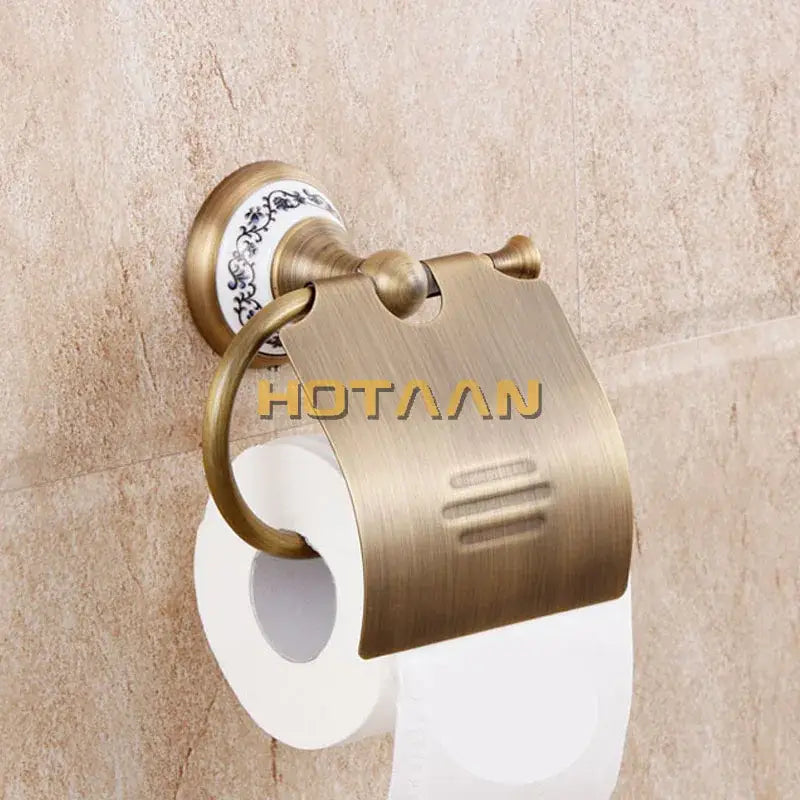 Antique brass toilet paper holder with decorative ceramic backplate and brushed metal cover from brass bathroom accessories set