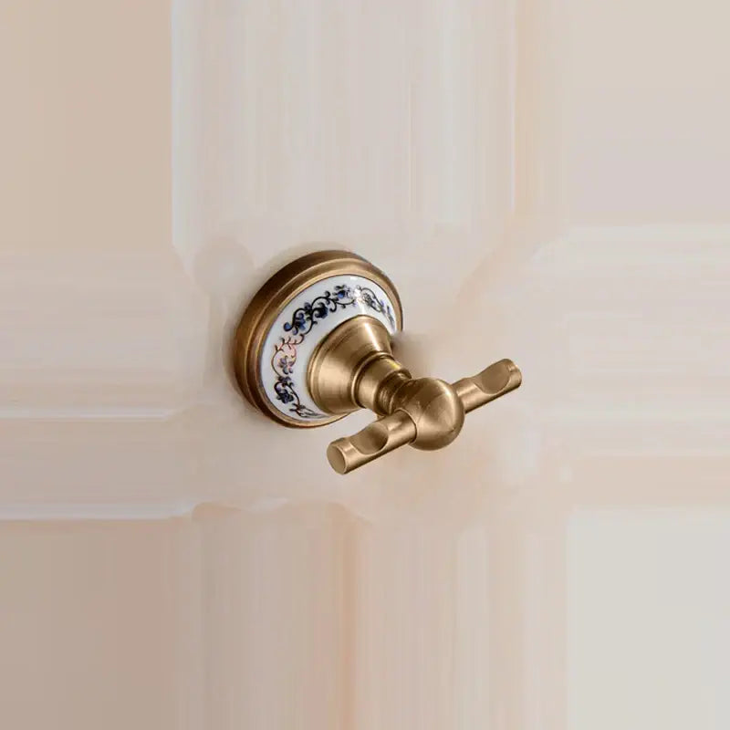 Antique brass towel rack with white ceramic base featuring blue and pink floral patterns from brass bathroom accessories set