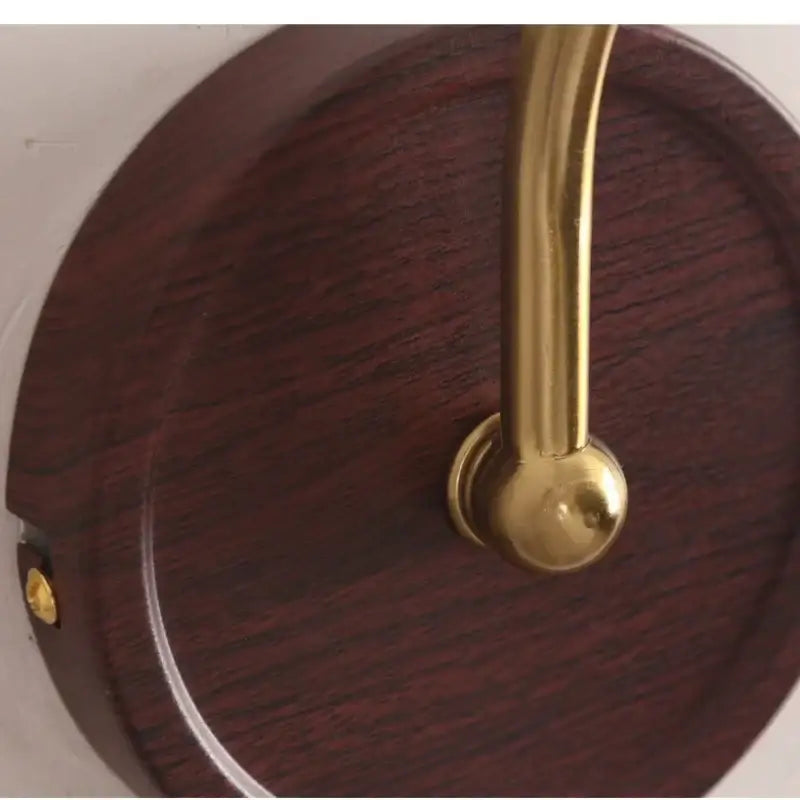 A polished brass handle with spherical knob on dark wood base for antique brass and wood led wall light decorbites led wall