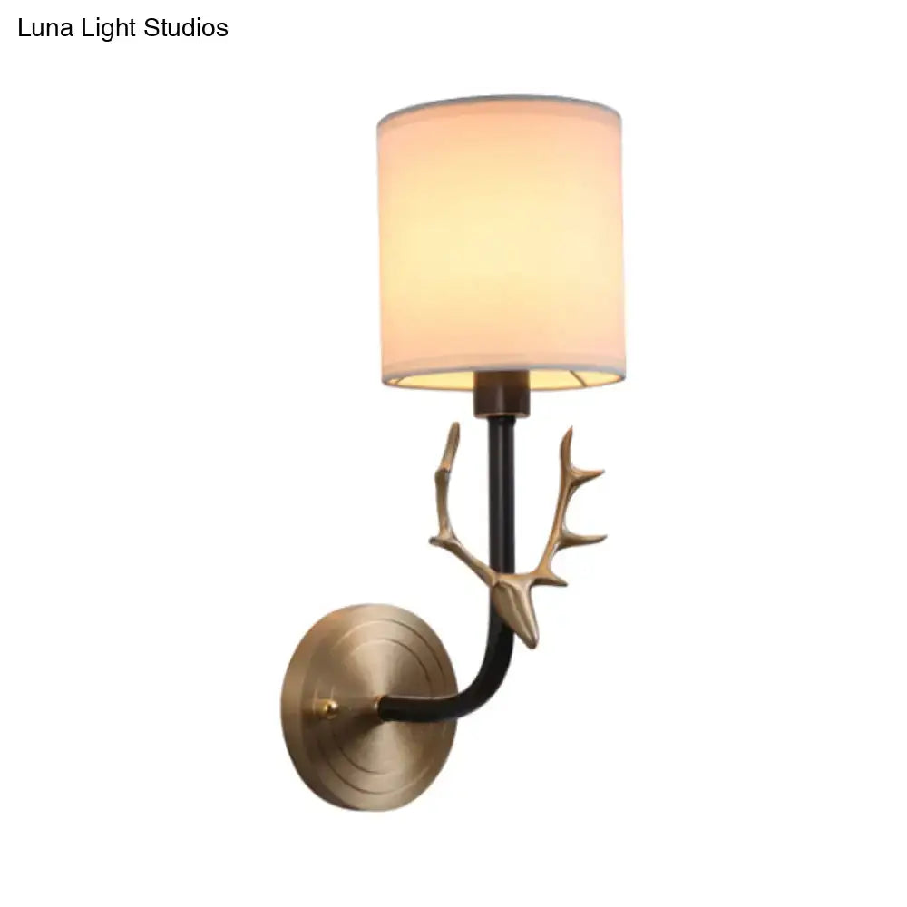 Antique brass antler wall sconce with warm-toned fabric shade and stylish design for bedroom lighting