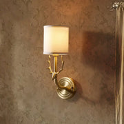 Antique brass wall sconce with deer antler design and off-white fabric shade for stylish bedroom lighting