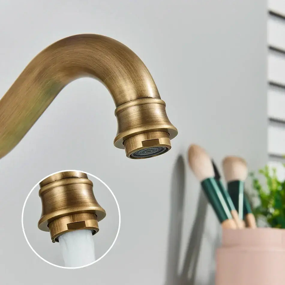 Antique brass basin faucet with swivel single handle and curved spout featuring decorative ridged detailing for bathroom use
