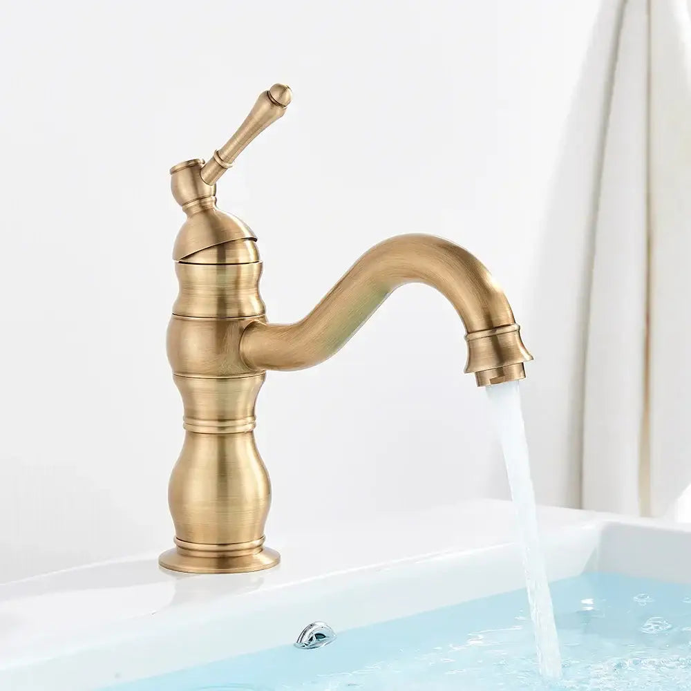 Antique brass basin faucet with single handle, swivel curved spout, and decorative ridged body for bathroom use