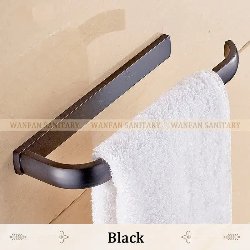 Black matte metal towel rack holding a white plush towel from decorbites brass bathroom accessories set with towel rings