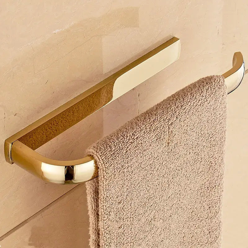 Antique brass bathroom accessories set with gold-toned metal towel rack and soft beige terry cloth towel decorbites brass bathroom