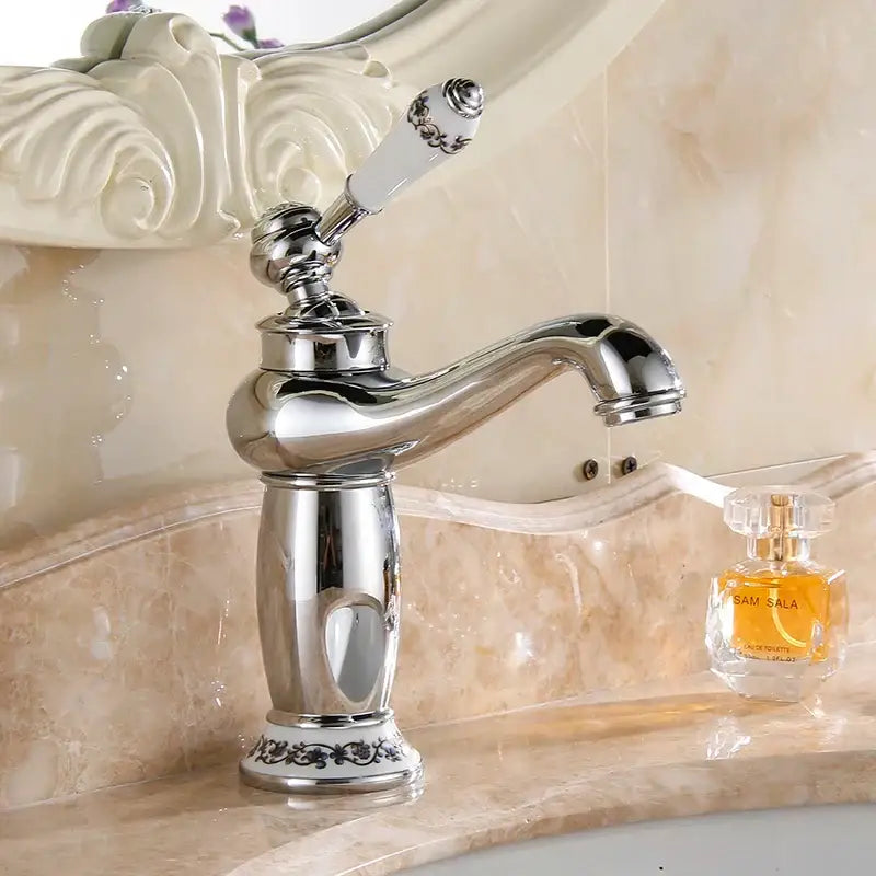 Chrome finished brass bathroom basin water mixer with ornate white ceramic handle and black floral detailing decorbites brass bathroom