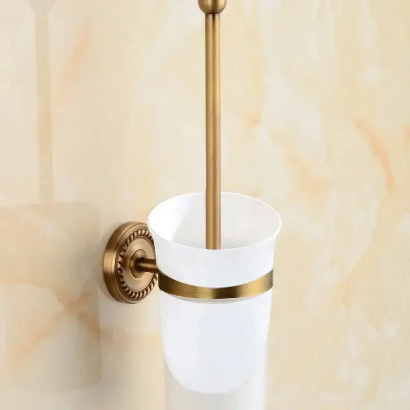 White ceramic toilet brush holder with brass bathroom set featuring ornate mounts and gold-toned decorbites brass accents