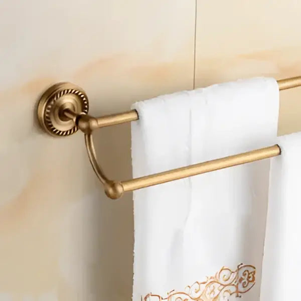 Gold-toned brass bathroom double-bar towel rack with ornate circular mounting plate from decorbites brass bathroom set