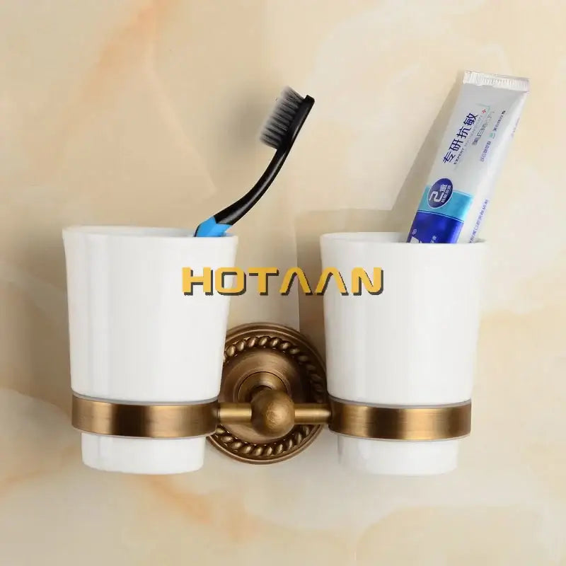 White ceramic toothbrush holder with brass accents and vintage-style mount in decorbites brass bathroom set