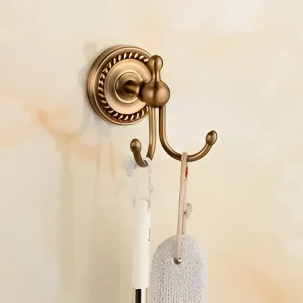 Antique brass bathroom set featuring a decorbites brass bathroom wall-mounted triple hook with ceramic brush cup holding brush and sponge