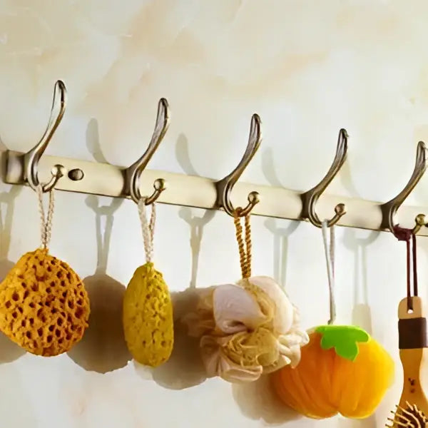 A set of colorful textured bath sponges hanging on a metal rack in an antique brass bathroom set by decorbites brass bathroom