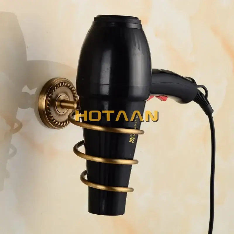 Black hair dryer mounted in a brass wall holder with spiral design from decorbites brass bathroom set