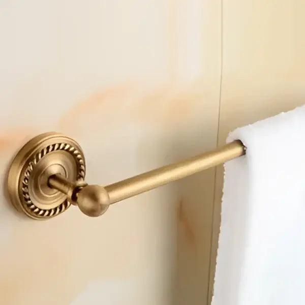 Brass-finished towel rack with ornate circular base and decorative bead detailing from decorbites brass bathroom set