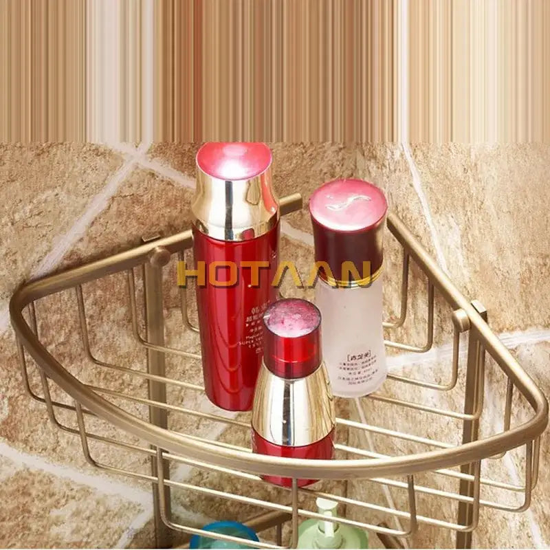 Antique brass bathroom shower shelf two tier corner caddy with hooks holding skincare bottles with red and gold caps