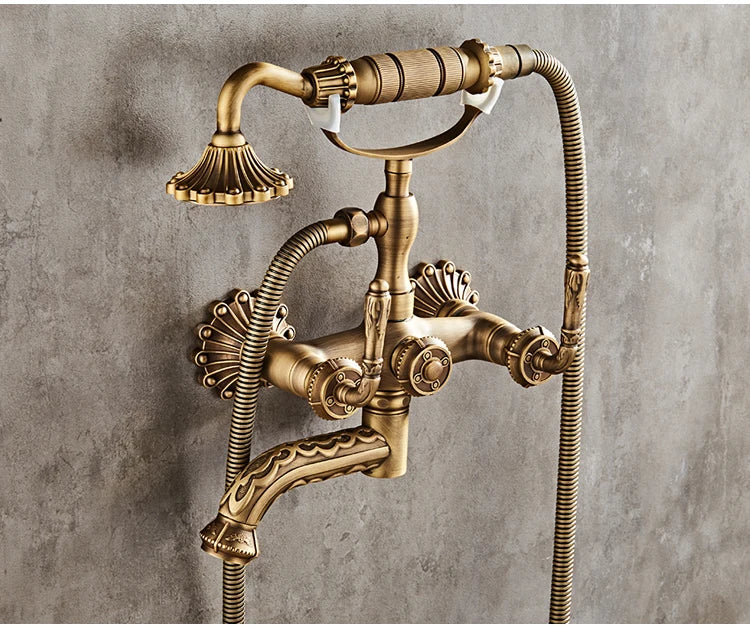 Antique brass bathtub shower set with vintage wall-mounted faucet featuring ornate detailing and flexible hoses