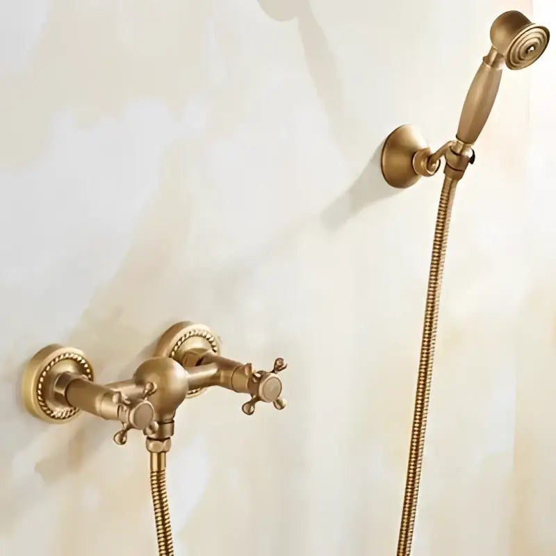 Antique brass bathtub shower set with ceramic handles featuring an antique brass-finished faucet and matching handheld showerhead