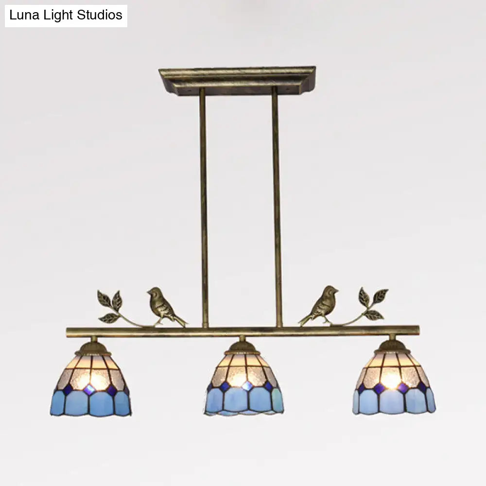Antique brass indoor island pendant with three blue stained glass shades and decorative bird motifs for kitchen