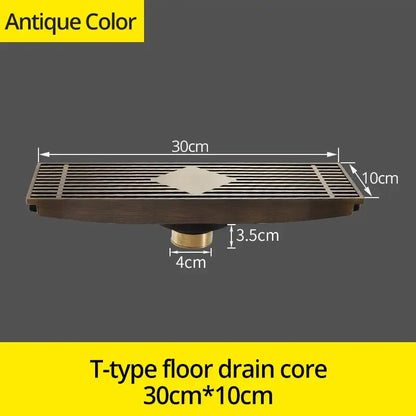 Antique brass t-type floor drain cover with rectangular grille and diamond-shaped floral accent for bathroom use