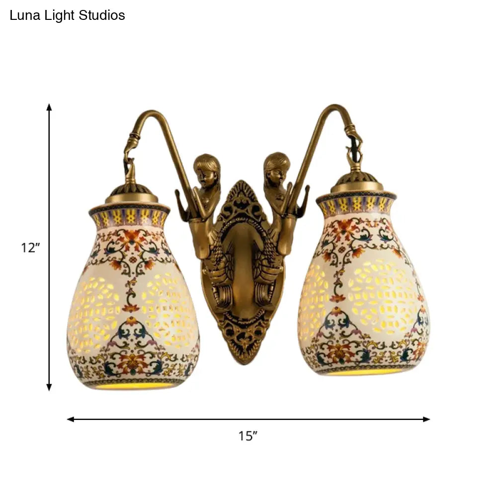 Aplique de pared de latón antiguo con cerámica, jarrón perforado, diseño tradicional y pequeño detalle de sirena.