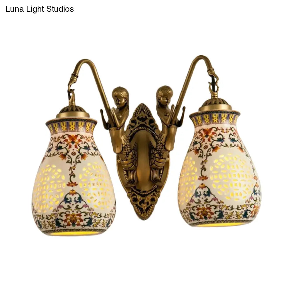 Aplique de pared de latón antiguo con cerámica, jarrón perforado, diseño tradicional y pequeño detalle de sirena.