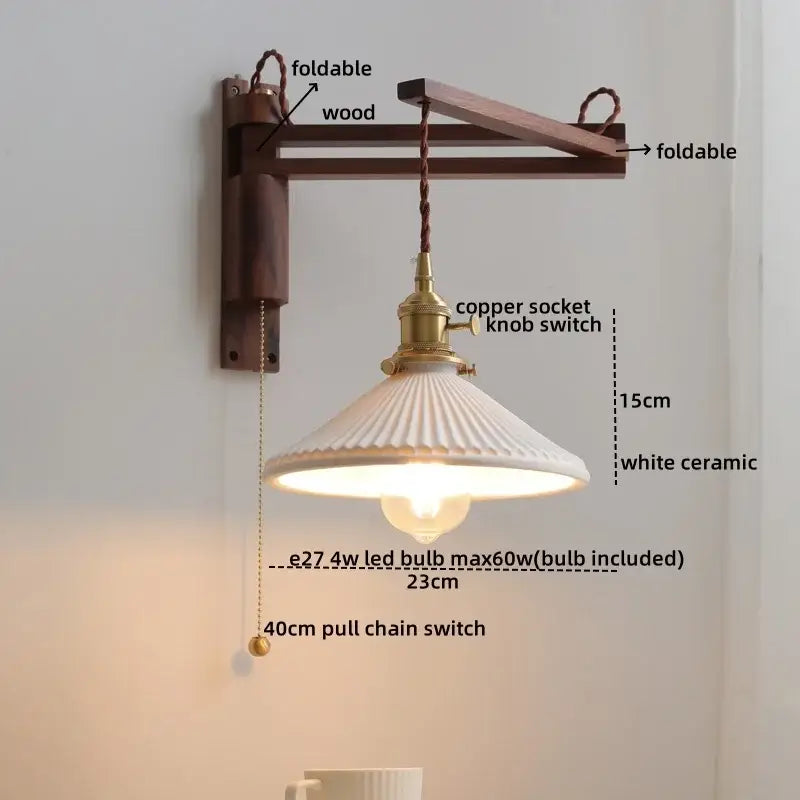 A white ceramic walnut wall sconce with a fluted scalloped shade hangs from an antique brass foldable arm decorbites ceramic walnut wall