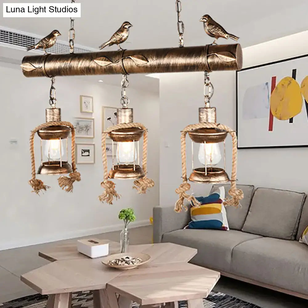 Rustic bronze antique brass lantern chandelier with three clear glass lamps rope accents and decorative bird accents on wooden beam