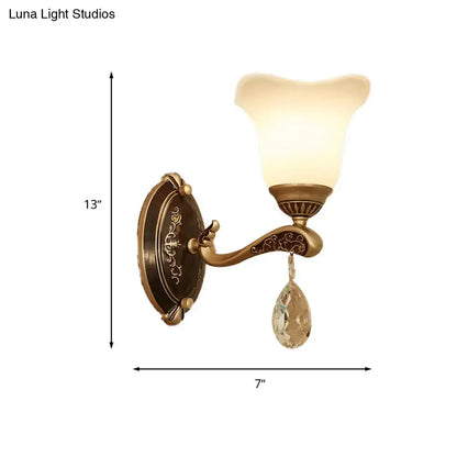 Antique brass crystal drop wall lamp with ornate curved arm and teardrop pendant with e12 e14 base for bedroom sconce