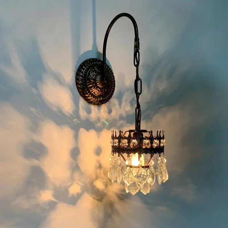 Antique brass crystal wall lamp featuring a bronze sconce with cascading crystal decorbites crystal wall design
