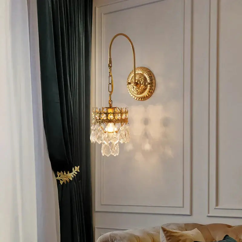 Antique brass crystal wall lamp with gold-toned curved arm and chandelier-style pendant for luxury bedroom decorbites crystal wall lamp